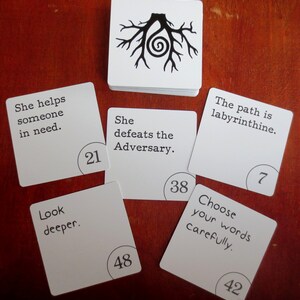 May include: A set of white cards with black text and numbers. The cards feature phrases like "She helps someone in need." and "The path is labyrinthine."