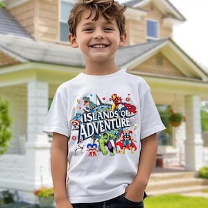 May include: A white t-shirt featuring the text "Universal Islands of Adventure" with various cartoon superhero characters. The shirt is worn by a smiling child. The background shows a house with a green lawn.