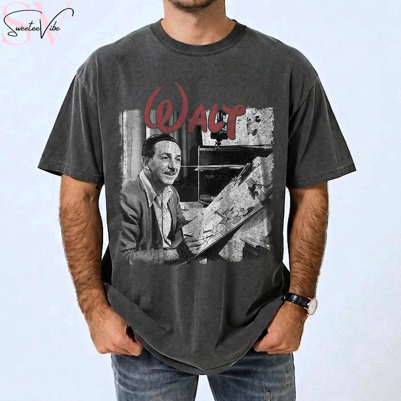 May include: Dark gray t-shirt featuring a black and white image of Walt Disney, with the word "Walt" in red script above the image. The shirt has a vintage, distressed look.