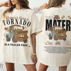 Puede incluir: Camiseta de color marfil con un dibujo de un cami&oacute;n de remolque de dibujos animados y el texto "Happier than a Tornado in a Trailer Park" en la parte delantera. La parte trasera de la camiseta muestra "Tow Mater" con un gr&aacute;fico a juego. La camiseta es de material c&oacute;modo.
