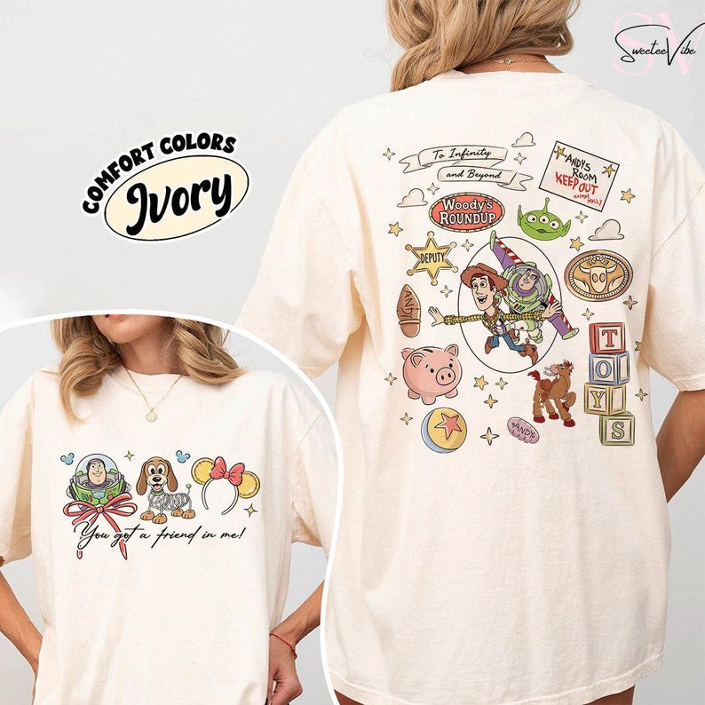 May include: Ivory-colored t-shirt featuring Toy Story characters and phrases. The front displays a graphic with Buzz Lightyear, a dog, and Minnie Mouse ears. The back showcases Woody, Buzz, and other characters with the text "To Infinity and Beyond."