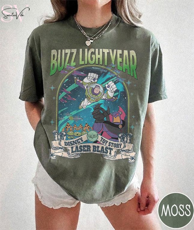 Puede incluir: Camiseta verde musgo con un gr&aacute;fico de Buzz Lightyear de Toy Story de Disney. El dise&ntilde;o incluye las palabras "Buzz Lightyear", "Disney", "Toy Story" y "Laser Blast". El gr&aacute;fico es en tonos de verde, azul, morado y blanco.