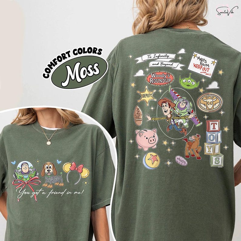 May include: Moss green t-shirt featuring Toy Story characters. The front displays Buzz Lightyear, a dog, and Minnie Mouse ears with the text "You got a friend in me!". The back has Woody, Buzz, and other characters with the text "To Infinity and Beyond".