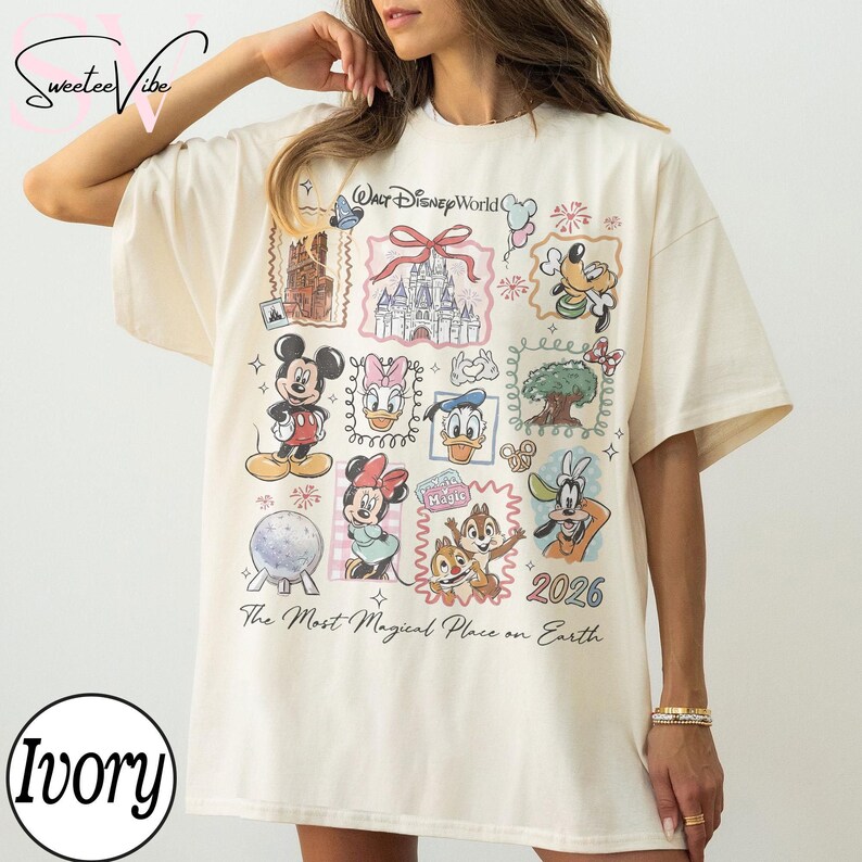 Puede incluir: Camiseta de color marfil con un dise&ntilde;o de Disney. El estampado incluye varios personajes de Disney como Mickey y Minnie Mouse, y Donald Duck. La camiseta tambi&eacute;n presenta el texto "Walt Disney World", "2026" y "The Most Magical Place on Earth".