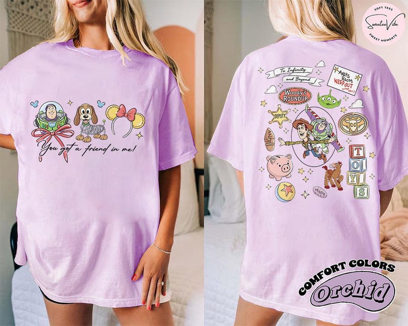 May include: A light purple t-shirt featuring Toy Story characters. The front displays Buzz Lightyear, a dog, and Minnie Mouse ears with the text "You got a friend in me!". The back has more characters and the text "To Infinity and Beyond".