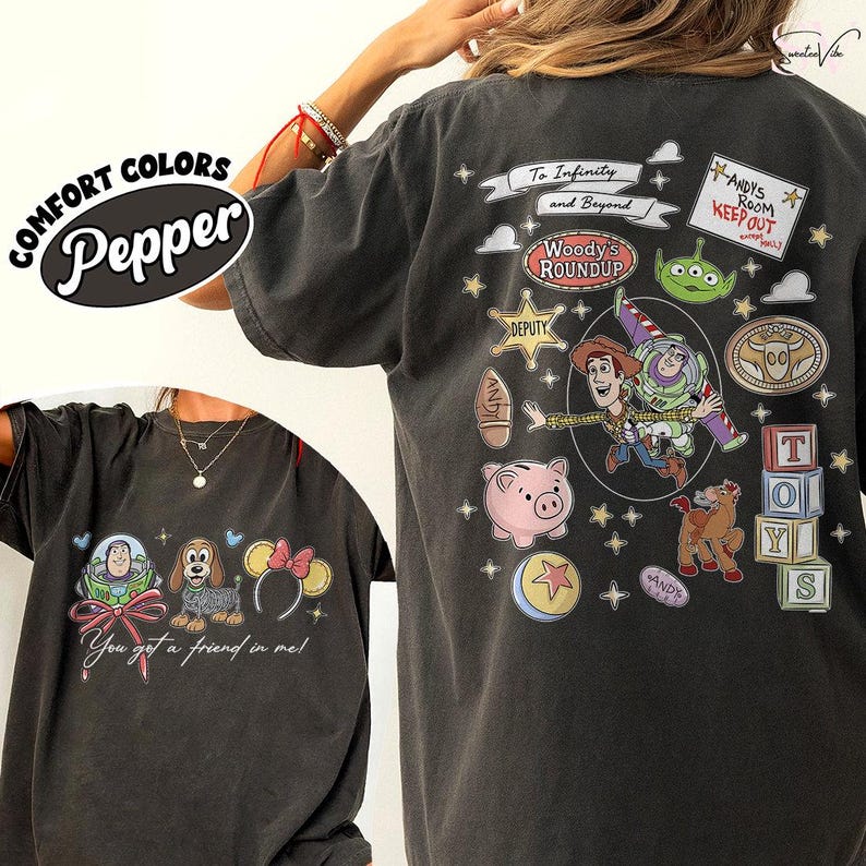 May include: Pepper-colored t-shirt featuring Toy Story characters and phrases. The front displays a graphic with Buzz Lightyear, a dog, and Minnie Mouse ears. The back showcases Woody, Buzz, and other characters with the text "To Infinity and Beyond."