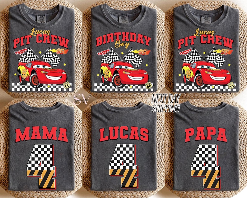 May include: Gray t-shirts with various designs. Some shirts say "Lucas PIT CREW" with a red race car graphic. Others say "BIRTHDAY Boy", "MAMA", "LUCAS", and "PAPA" with a number 4 graphic. The shirts are displayed on a woven surface.
