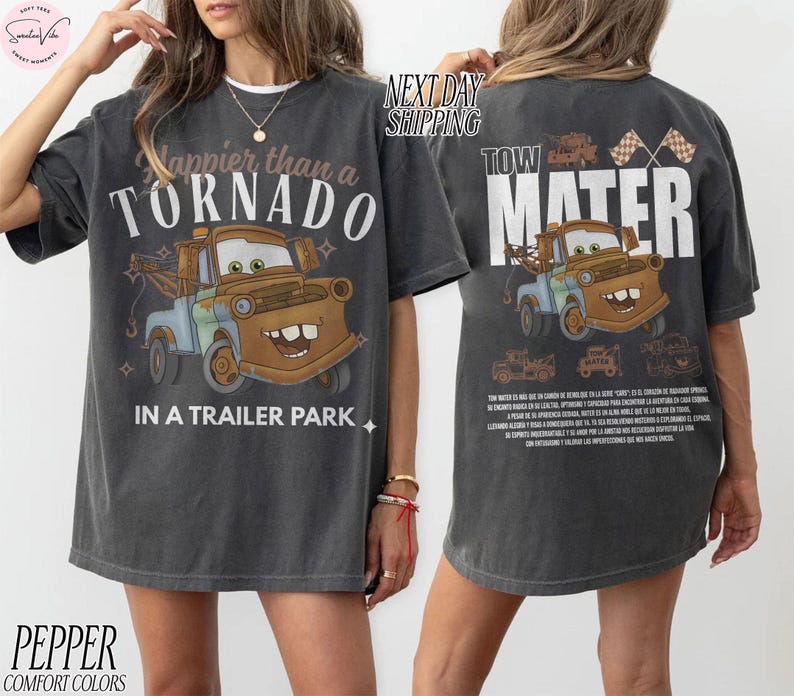 Puede incluir: Camisetas de color gris oscuro con un gr&aacute;fico de Tow Mater de la pel&iacute;cula Cars. La parte delantera de la camiseta dice "Happier than a Tornado in a Trailer Park". La parte trasera dice "Tow Mater".