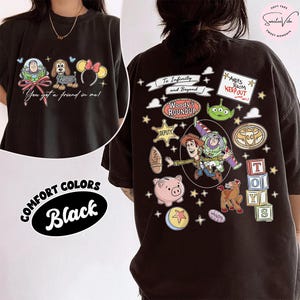May include: Black comfort colors t-shirt featuring Toy Story characters. The front displays Buzz Lightyear, a dog, and Minnie Mouse ears with the text "You got a friend in me!". The back has various Toy Story graphics and text.