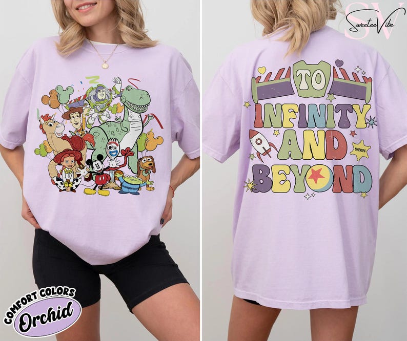 Op de afbeelding: Een lichtpaars T-shirt met een kleurrijke afbeelding van Toy Story-personages op de voorkant. De achterkant van het shirt heeft de tekst "To Infinity and Beyond" in een regenboogontwerp. Het shirt is een Comfort Colors Orchid.