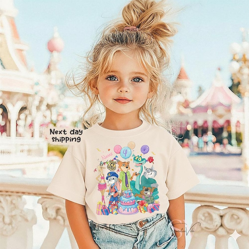 Peut inclure: Un t-shirt cr&egrave;me avec un dessin anim&eacute; color&eacute; d'animaux c&eacute;l&eacute;brant un anniversaire. Le motif comprend un g&acirc;teau, des ballons et le chiffre 4. Les mots "Next day shipping" sont imprim&eacute;s sur le t-shirt.
