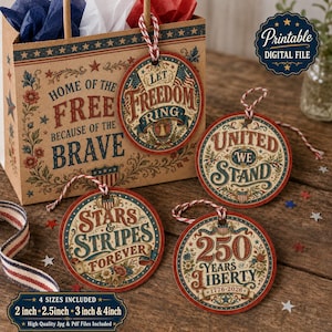 May include: A patriotic-themed gift bag and four round tags with red, white, and blue designs. The tags feature phrases like "Let Freedom Ring" and "Stars & Stripes Forever." The bag reads "Home of the Free Because of the Brave."