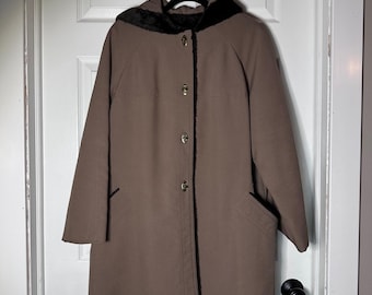 May include: A brown coat with a hood and black faux fur trim. The coat has a button-up front with gold-colored buttons and two front pockets. The coat is hanging on a black hanger.