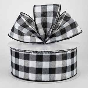 May include: Black and white buffalo plaid ribbon with a wired edge. The ribbon is 2.5 inches wide and is shown tied in a bow.