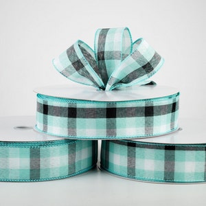 May include: Three spools of turquoise and black checkered ribbon. The ribbon is a woven fabric with a subtle sheen.