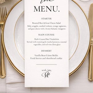 Puede incluir: Una tarjeta de menú formal con la palabra "MENU" en escritura elegante. El menú enumera un entrante de ensalada de remolacha asada y queso de cabra, un plato principal de solomillo de ternera con costra de hierbas y crema brûlée de vainilla para el postre. La tarjeta está en un plato blanco con ribete dorado.