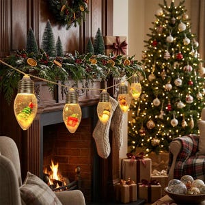 May include: A string of decorative light bulbs shaped like large vintage filaments, each containing a miniature holiday scene with a Christmas tree, a gift box, or a snowman. The clear glass bulbs are suspended on a rustic twine cord.