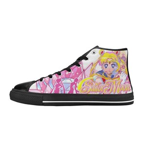 Pu&ograve; includere: Sneakers alte in tela con puntale e suola neri. Il pannello laterale mostra una grafica colorata di Sailor Moon con la scritta "Sailor Moon" in giallo. Sono presenti anche forme geometriche rosa e bianche.