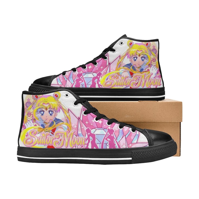 Pu&ograve; includere: Scarpe da ginnastica alte in tela con un design di Sailor Moon. Le scarpe hanno una suola e un puntale in gomma nera, con una tomaia bianca ornata da grafiche rosa, gialle e blu. Il testo "Sailor Moon" &egrave; visibile sul lato.