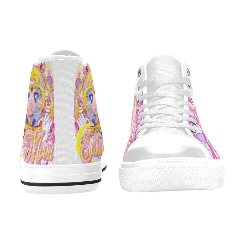 Pu&ograve; includere: Scarpe da ginnastica alte bianche con un colorato design di personaggi anime. Il design include accenti rosa, gialli e blu, con la parola "Sailor" visibile. Le scarpe da ginnastica hanno lacci bianchi e una suola in gomma bianca.