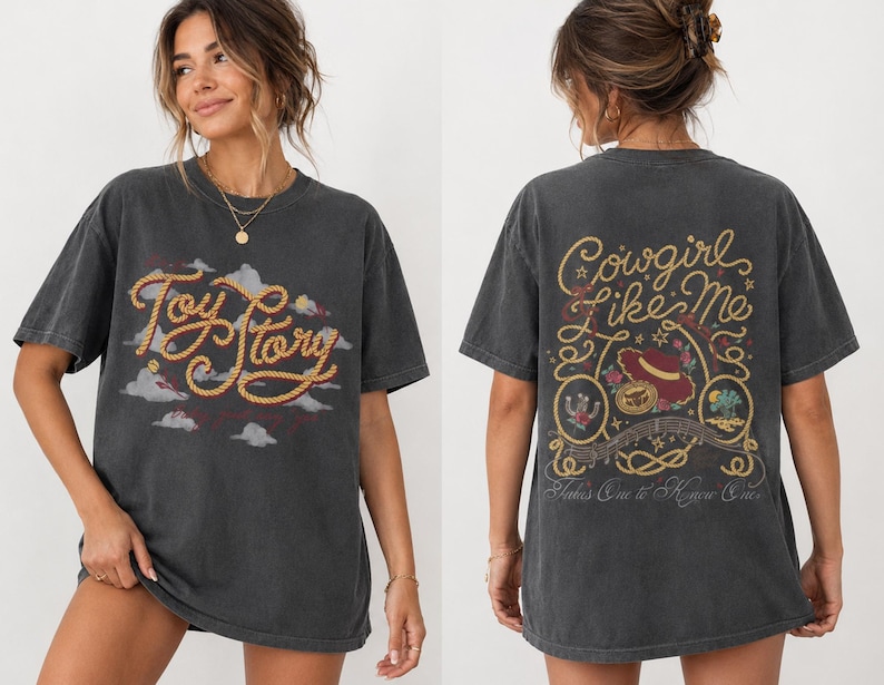 Op de afbeelding: Een antracietgrijs t-shirt met korte mouwen en een vooropdruk met de tekst Toy Story in een touwachtig lettertype boven wolken. De achterkant toont de tekst Cowgirl Like Me en Takes One to Know One met een illustratie van een hoed en cactus.
