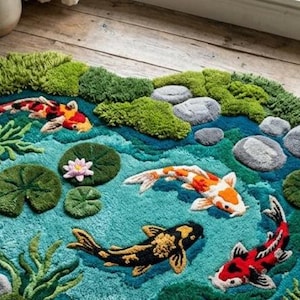 May include: A detailed rug featuring a pond scene with koi fish, lily pads, and rocks. The rug has a teal background with green, orange, black, and white koi fish. Green moss-like tufts and gray rocks add dimension to the design.