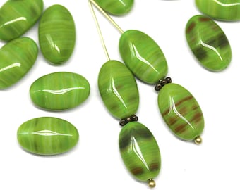 May include: A collection of green and brown oval-shaped glass beads with a striped pattern. The beads are strung on a gold wire.