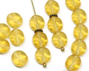 May include: A strand of yellow glass beads with a faceted oval shape. The beads are strung on a wire with small metal spacers between each bead.