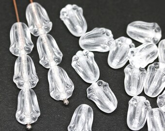 May include: A collection of clear glass beads in the shape of a flower. The beads have a textured surface and are strung on a wire.