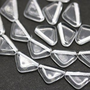 May include: A strand of clear glass triangle beads with white accents. The beads are strung together and have a shiny, reflective surface.