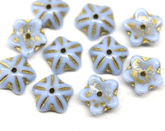 May include: Ten light blue star-shaped glass beads with gold accents. The beads have a raised design and a hole in the center.