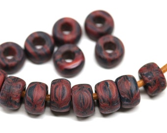 May include: A strand of red and black marbled beads with a brown leather cord. The beads are round and have a speckled pattern.
