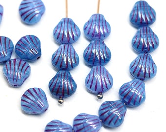May include: A collection of blue and purple glass beads shaped like seashells. The beads have a striated pattern and are strung on a wire.