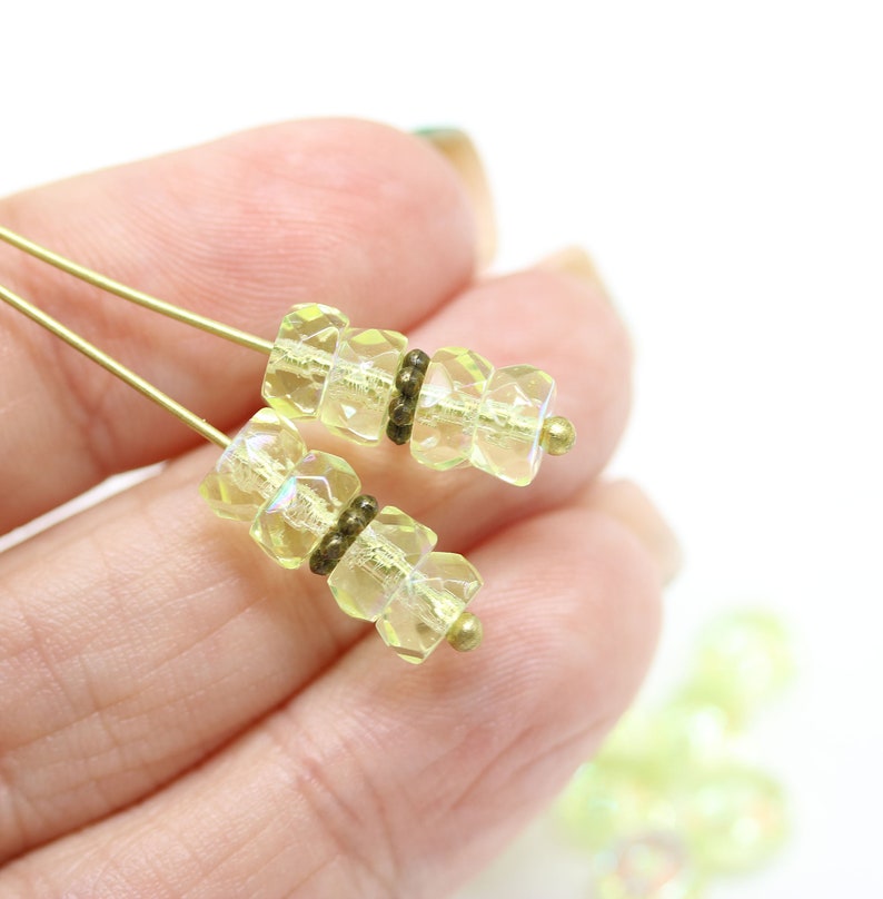 May include: Two strands of yellow faceted glass beads with gold accents. The beads are strung on a gold wire.