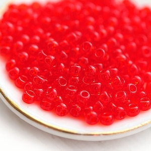 Contas de sementes TOHO: Vermelho rubi siam claro transparente, tamanho 11/0 (10g)