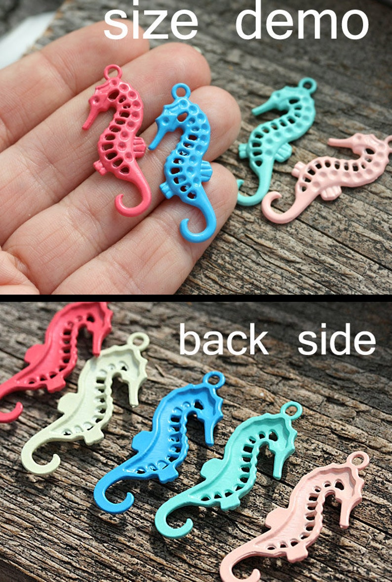 May include: A set of six seahorse charms in various colors, including pink, blue, and green. The charms are made of metal and have a delicate, intricate design. The charms are shown on a wooden surface.