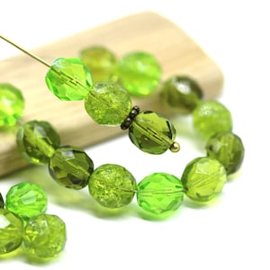May include: A strand of green glass beads with a faceted and textured finish. The beads are strung on a wire and have a gold-toned metal accent.