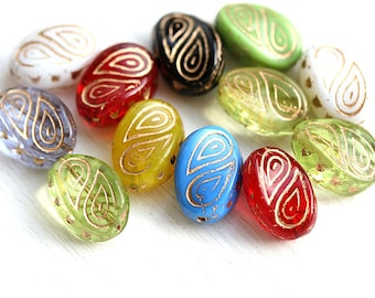 May include: Assortment of oval-shaped glass beads with gold swirl designs. The beads are in various colors, including red, blue, green, yellow, and white.