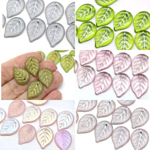 May include: Assortment of glass leaf-shaped beads in various colors, including silver, green, pink, and iridescent. The beads have a delicate, etched leaf design and a small hole for stringing.