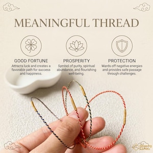 May include: Three thin, twisted cord bracelets in red, black, and blue, each featuring a small, cylindrical gold-colored metal bead. The background displays text reading MEANINGFUL THREAD, GOOD FORTUNE, PROSPERITY, and PROTECTION with icons.
