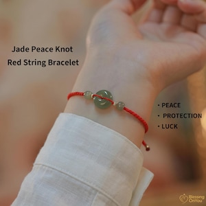 May include: A red string bracelet featuring a central green jade peace knot, flanked by two smaller jade beads. The text reads: Jade Peace Knot Red String Bracelet, PEACE, PROTECTION, LUCK, and Blessing OnYou.