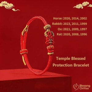 May include: A red Temple Blessed Protection Bracelet with gold detailing. The knotted bracelet has decorative elements. Text on the image includes the years for the Horse, Rabbit, Ox, and Rat zodiac signs.