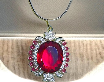 Collar con colgante de granate rojo en plata de ley y detalle de zafiro blanco. Incluye caja de regalo.