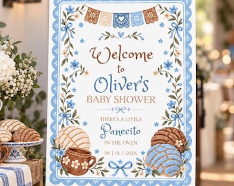 May include: A rectangular baby shower welcome sign on a wooden easel. The sign features blue floral borders, brown and blue text reading Welcome to Oliver's BABY SHOWER THERE'S A LITTLE Panecito IN THE OVEN 06 | 01 | 202X, and illustrations of conchas.