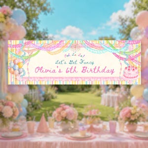 May include: A rectangular birthday banner featuring a cream-colored center with the text Ooh La La, Let's Get Fancy, and Olivia's 6th Birthday in pink and blue. The border displays colorful streamers, balloons, and a cake illustration.