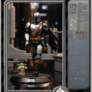K&ouml;nnte beinhalten: Star Wars Mandalorian Grogu Modellbausatz. Die detaillierte Figur des Mandalorianers in silberner und schwarzer R&uuml;stung, mit Umhang, und eine Grogu-Figur. Die Figuren stehen auf einer schwarzen Basis mit dem Star Wars-Logo. Der Bausatz enth&auml;lt Modellteile.