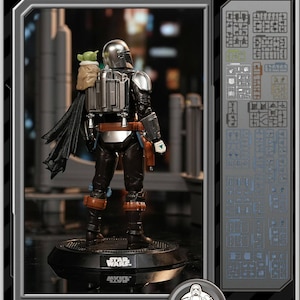 K&ouml;nnte beinhalten: Ein Star Wars Mandalorian Grogu Modellbausatz. Die Figur hat einen silbernen Helm, schwarze R&uuml;stung und einen Umhang. Das Set enth&auml;lt Grogu und wird auf einer schwarzen Basis mit dem Star Wars-Logo pr&auml;sentiert. Die Box zeigt auch die Modellbausatzteile.