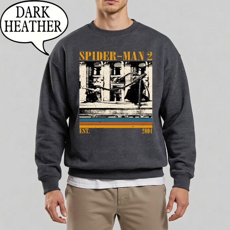 May include: Dark heather gray sweatshirt featuring a graphic from the movie Spider-Man 2. The design includes the movie title, a vintage-style image, and the year 2004. The sweatshirt has a crew neck and long sleeves.