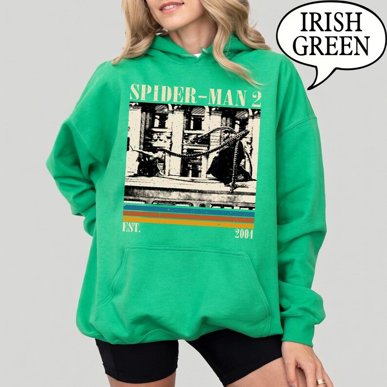 May include: Irish green hoodie featuring a Spider-Man 2 graphic. The graphic includes an image of Spider-Man and the text "SPIDER-MAN 2" above the image, with "EST. 2004" below. The hoodie has a drawstring hood and a kangaroo pocket.