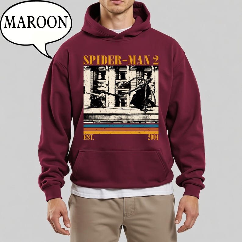 May include: Maroon hoodie featuring a graphic from the movie "Spider-Man 2." The design includes the movie title, a building image, and the text "EST. 2004." The hoodie has a front pocket and a hood with a drawstring.